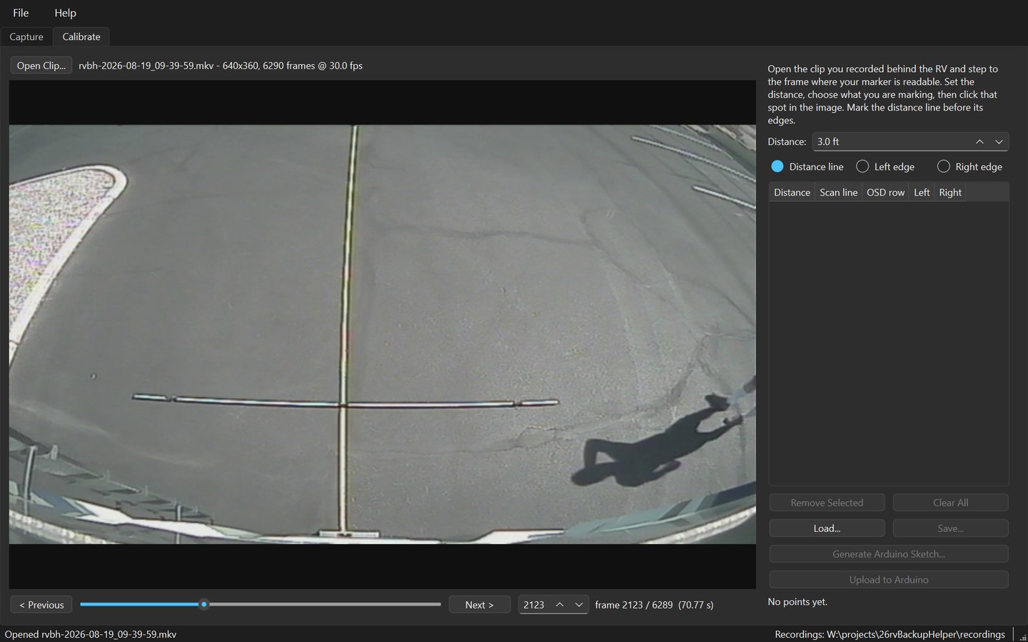 The Calibrate tab with a clip open, showing the driveway behind the RV with a marked pole lying across it, and the transport controls beneath the picture